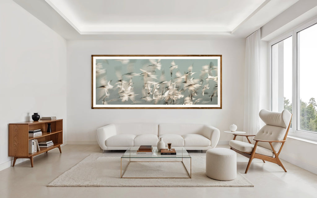Modern interior featuring a framed artwork of a Flock of birds flying against a light blue sky by Francoise V Fine Art Gallery in Cape Town, South Africa