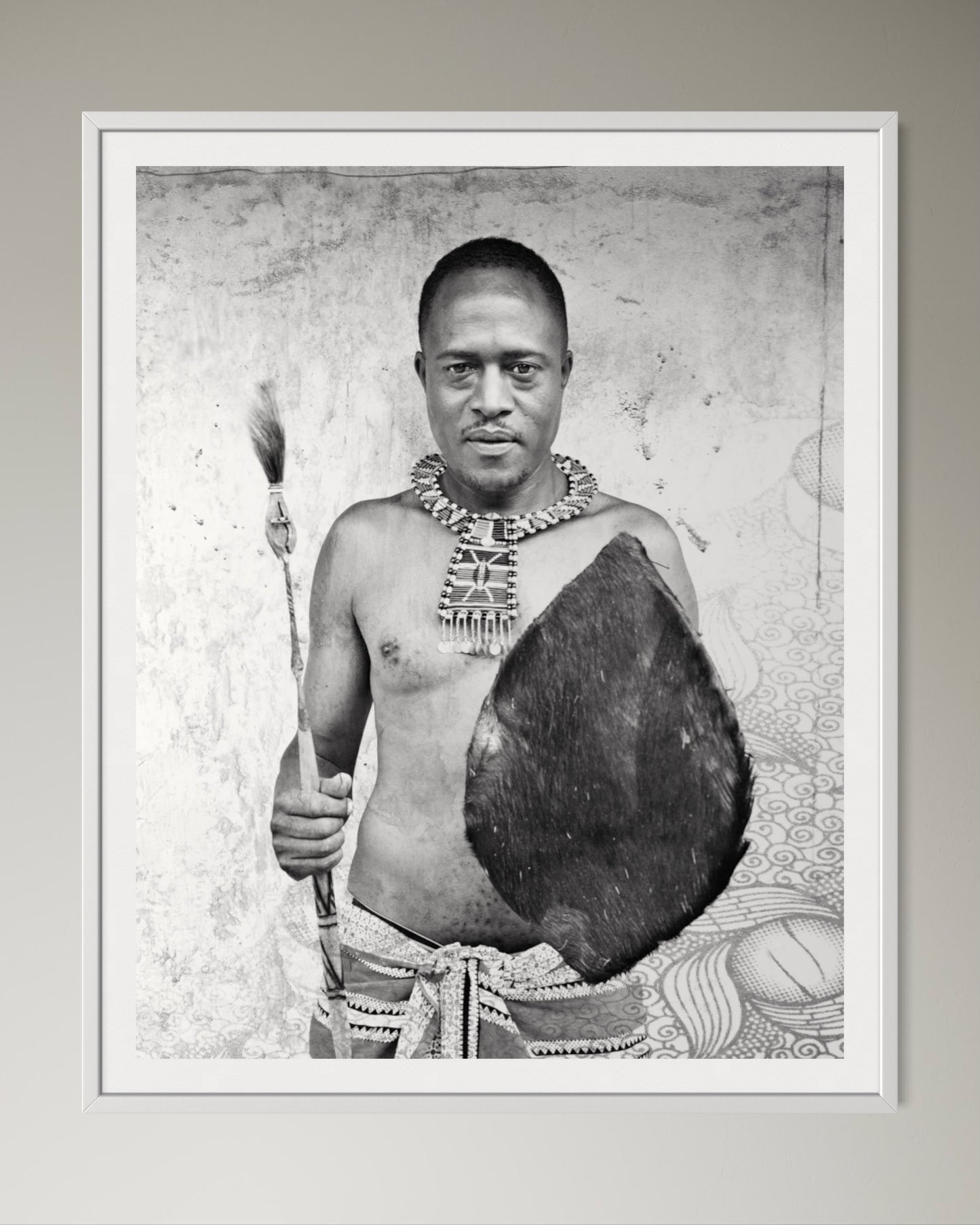 White box-framed Black and white portrait of a man holding a shield and spear against a textured wall by Francoise V Fine Art Gallery in Cape Town, South Africa