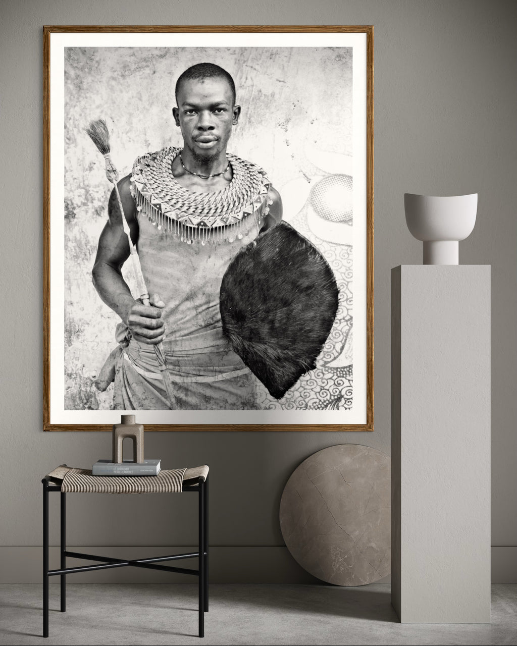 Modern interior featuring a Black and white portrait of a man holding a shield and spear against a textured wall by Francoise V Fine Art Gallery in Cape Town, South Africa