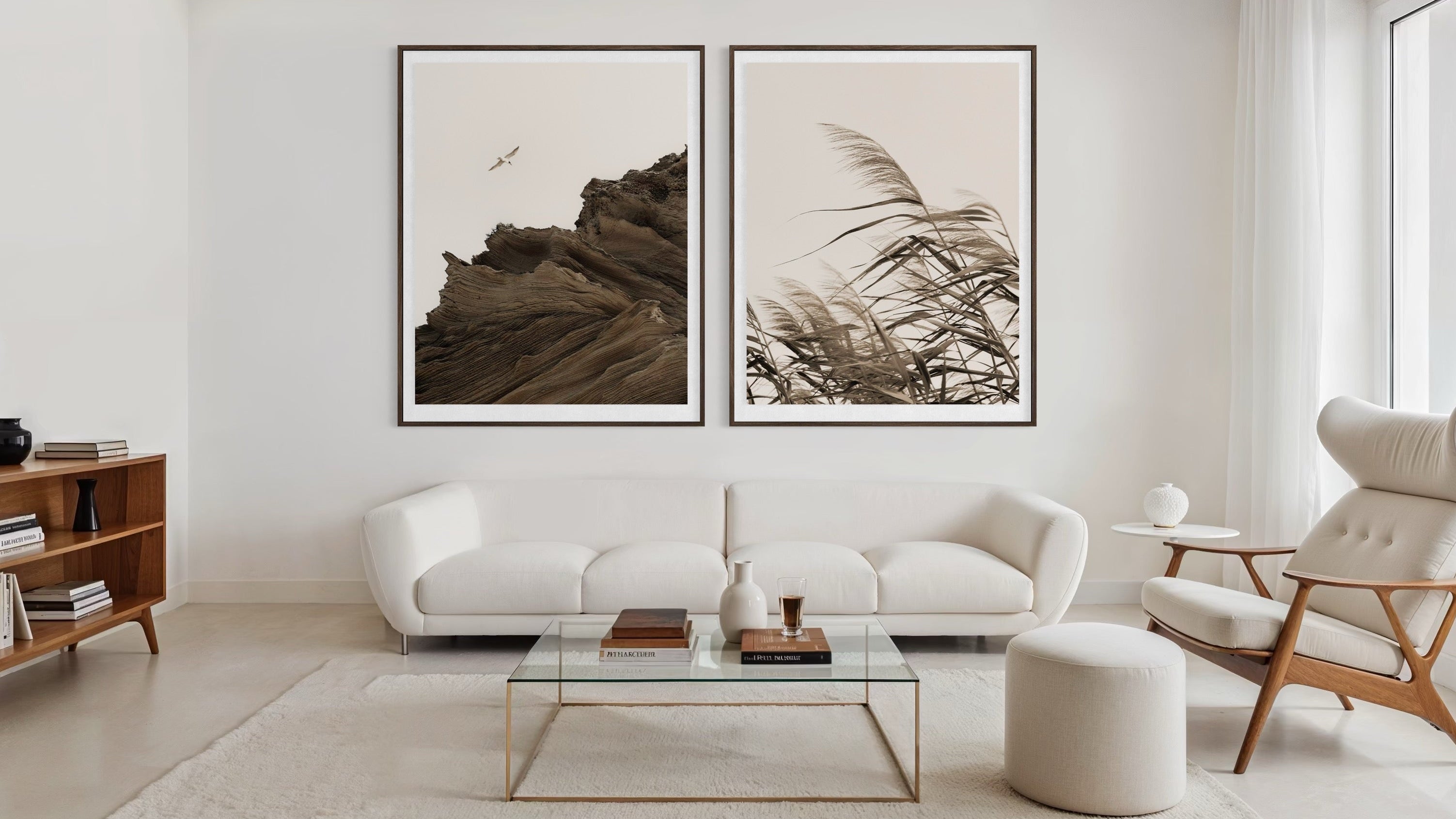 Modern living room with white furniture, a glass coffee table, and framed artwork on a white wall.