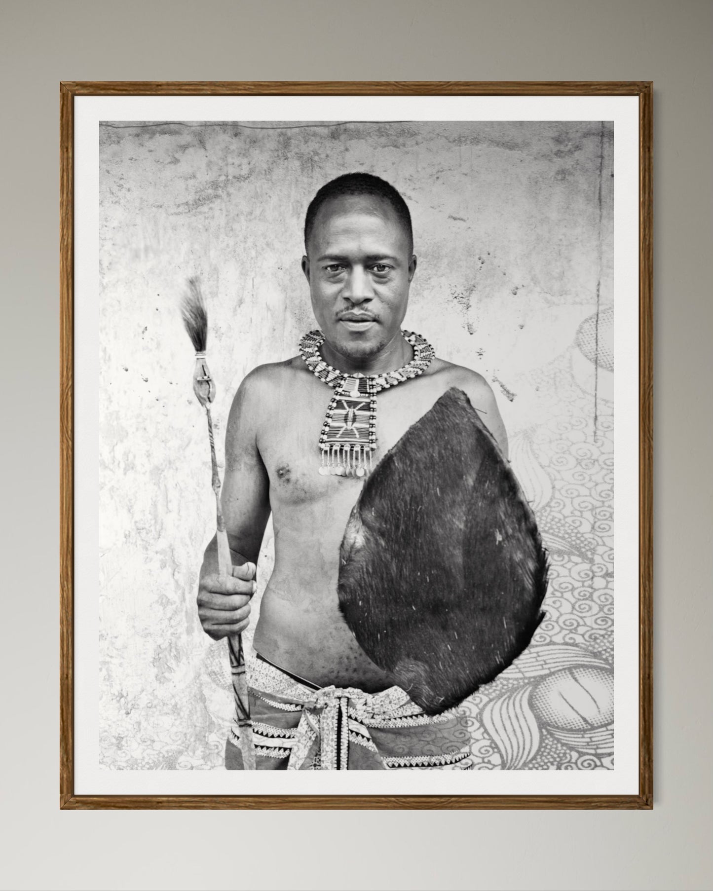 Natural Wood Kiaat framed Black and white portrait of a man holding a shield and spear against a textured wall by Francoise V Fine Art Gallery in Cape Town, South Africa